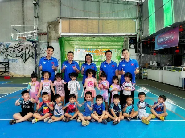 Giáo viên Cá Voi Xanh chụp ảnh cùng các học viên mầm non trên sân bóng rổ trong nhà tại 23 Nguyễn Công Trứ Kon Tum